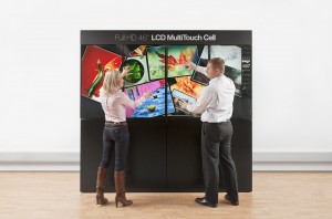 Two persons using simultaneously a wall made of 4 MultiTouch Cells